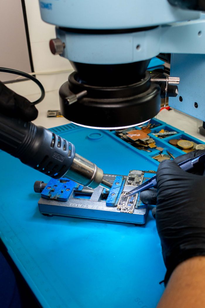 Mastering the First Impression: Your intriguing post title goes here Close-up of a technician using tools on a circuit board under a microscope.