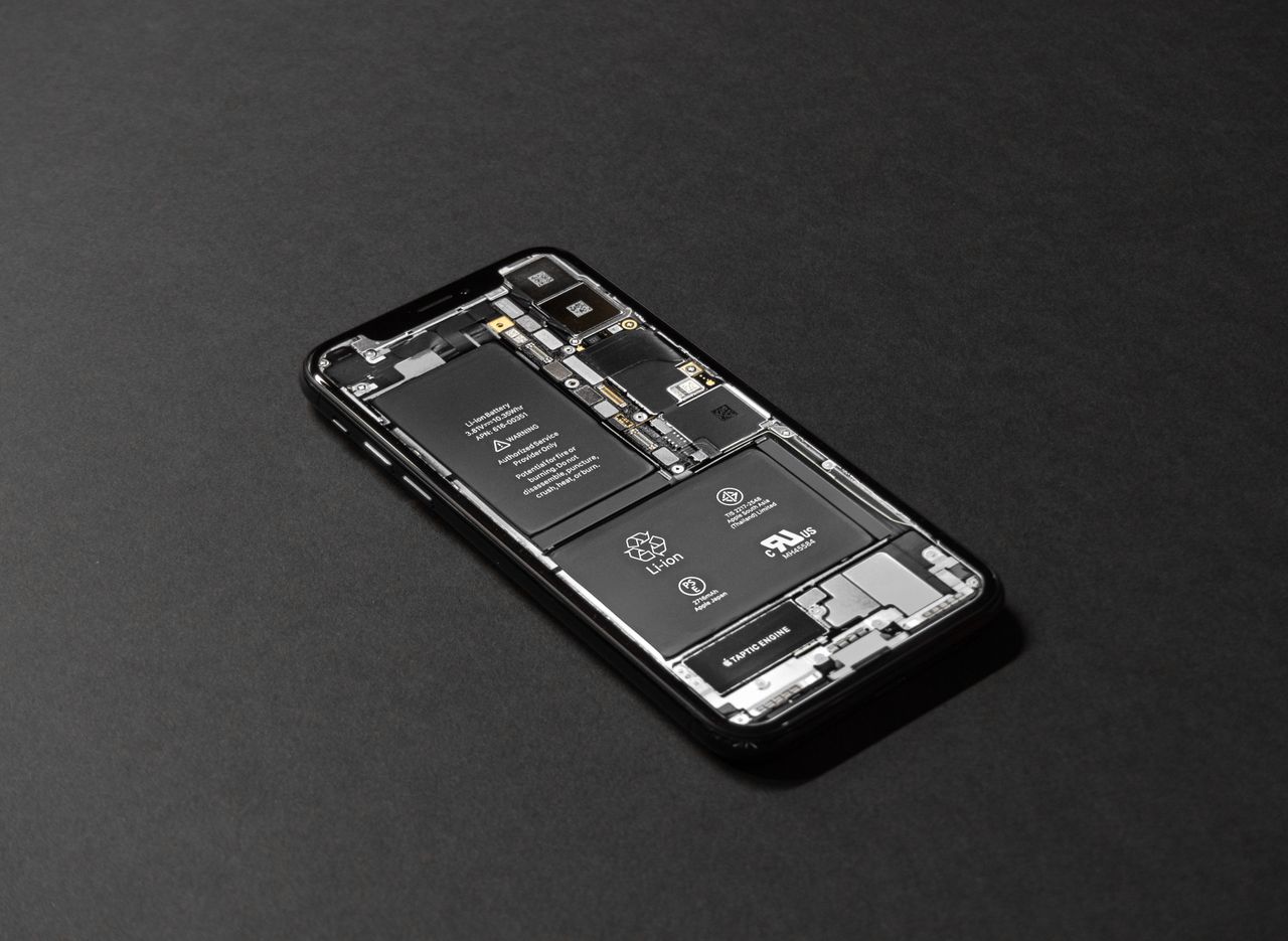 Services High-resolution image of a smartphone showcasing its internal components on a dark surface.